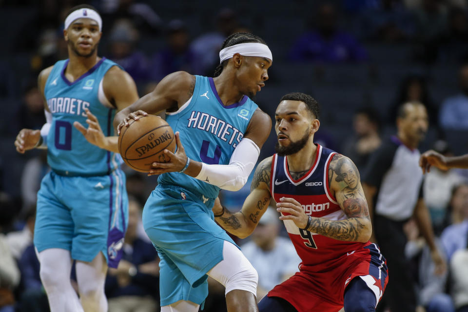Charlotte Hornets guard Devonte' Graham, left, looks for room to drive against Washington Wizards guard Chris Chiozza in the first half of an NBA basketball game in Charlotte, N.C., Tuesday, Dec. 10, 2019. (AP Photo/Nell Redmond)