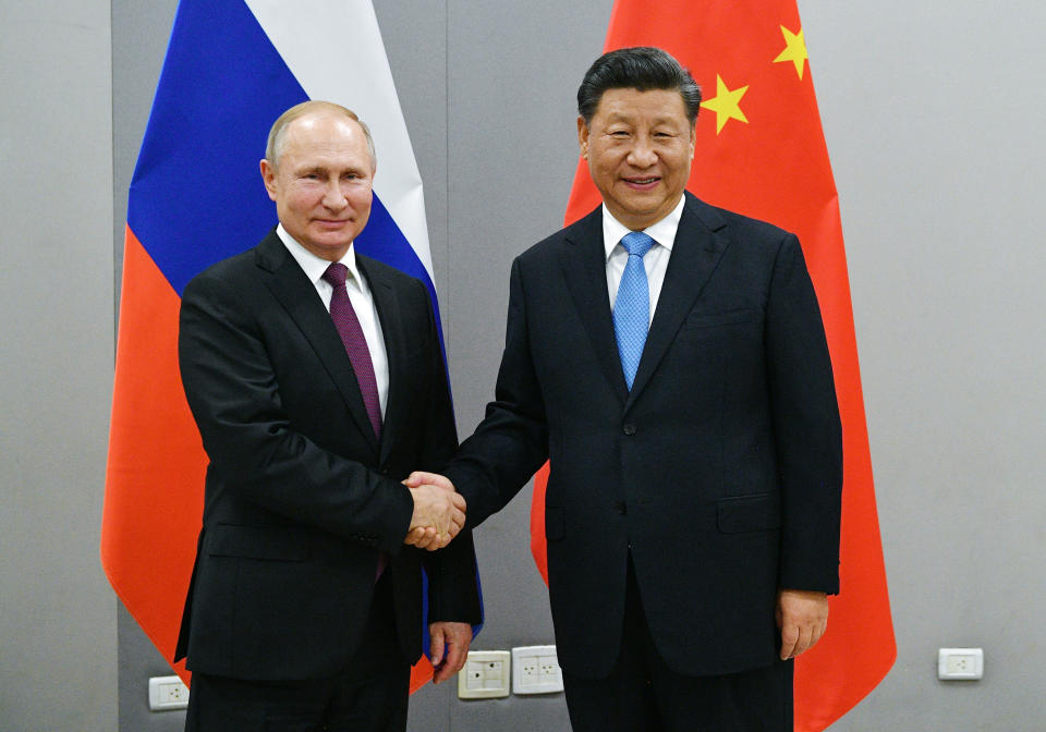 FILE - In this Nov. 12, 2019, file photo, Russian President Vladimir Putin, left, and China's President Xi Jinping shake hands prior to their talks on the sideline of the 11th edition of the BRICS Summit, in Brasilia, Brazil. Putin and Xi have developed strong personal ties helping bolster a “strategic partnership” between the two former Communist rivals. (Ramil Sitdikov/Sputnik, Kremlin/Pool Photo via AP, File)