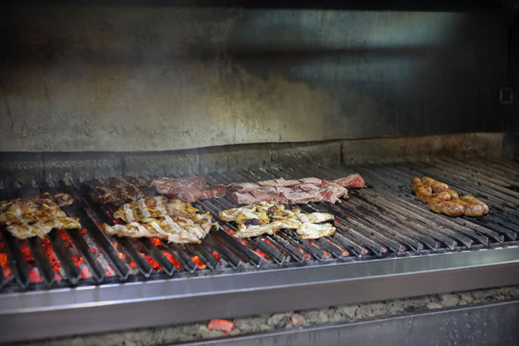 Slabs of meat cooking on a 'parrilla' or grill — Pictures by CK Lim