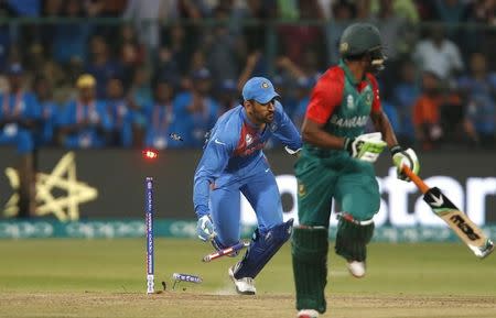 Cricket - India v Bangladesh - World Twenty20 cricket tournament - Bengaluru, India, 23/03/2016. India's captain and wicketkeeper Mahendra Singh Dhoni (L) runs out Bangladesh's Mustafizur Rahman. REUTERS/Danish Siddiqui