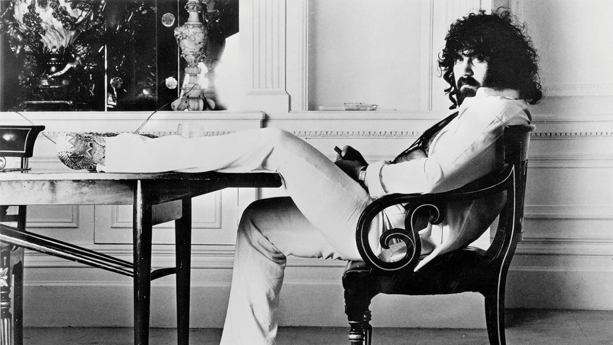  A photograph of Vangelis looking cool with his foot up on the table. 