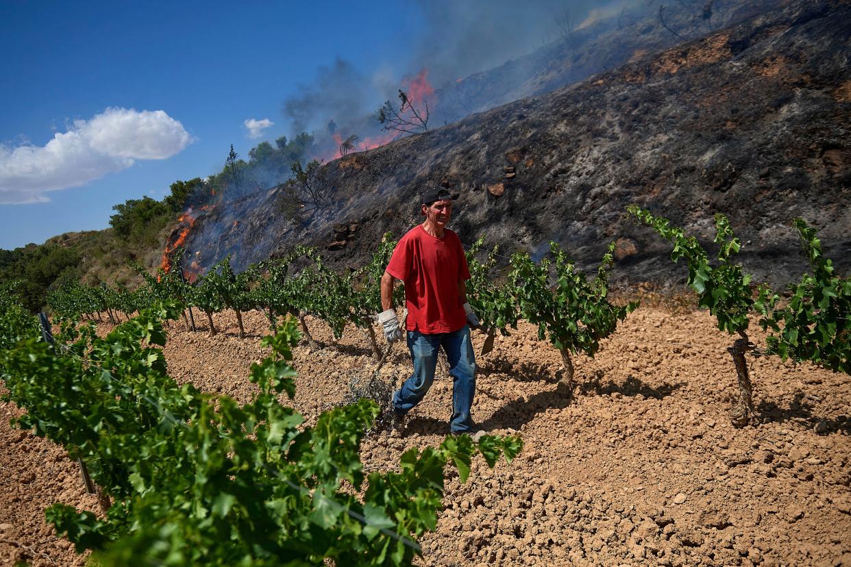 A neighbor from the nearby village of Olite, works to help put out a fire in San Martin de Unx in northern Spain, Sunday, June 19, 2022. 