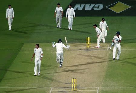 Australia's Peter Siddle (C) runs with team mate Mitchell Starc (R) after he hit the winning runs during the thrid day of the third cricket test match against New Zealand at the Adelaide Oval, in South Australia, November 29, 2015. REUTERS/David Gray