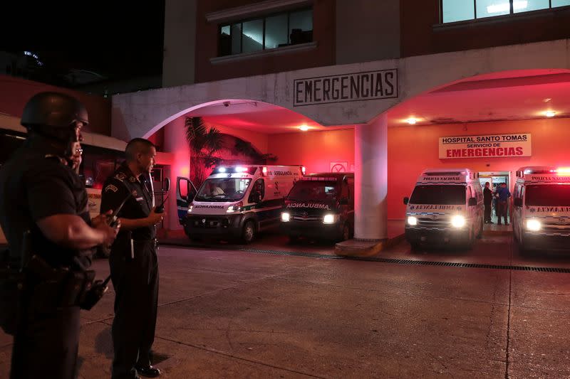 Police officers keep watch outside a hospital where injured inmates were taken following a shootout among inmates at La Joyita prison, in Panama City