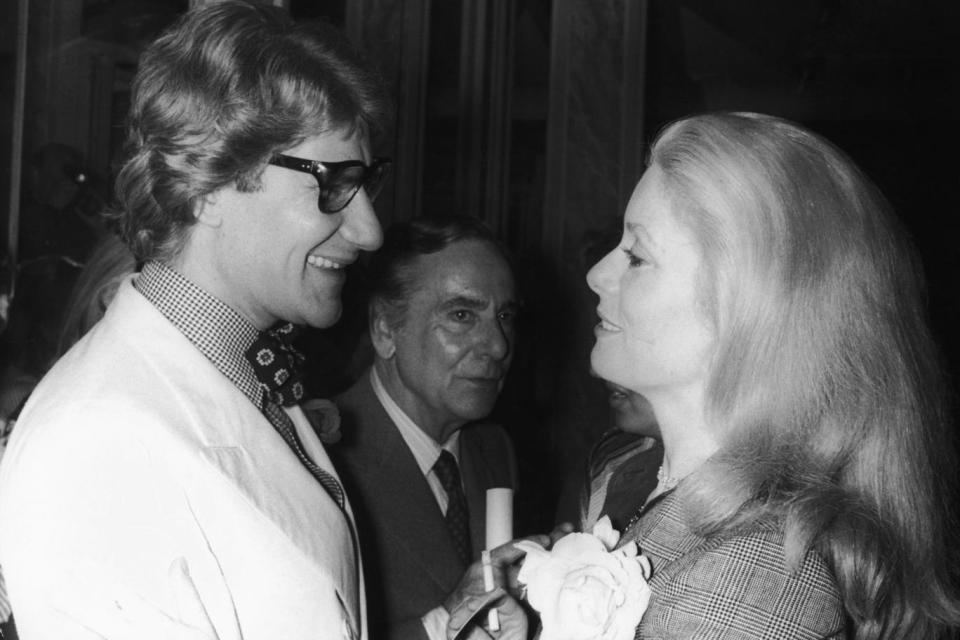 Yves Saint Laurent (1936 - 2008) with French actress Catherine Deneuve after the launch of his new collection, Paris, 24th July 1974. (Getty Images)