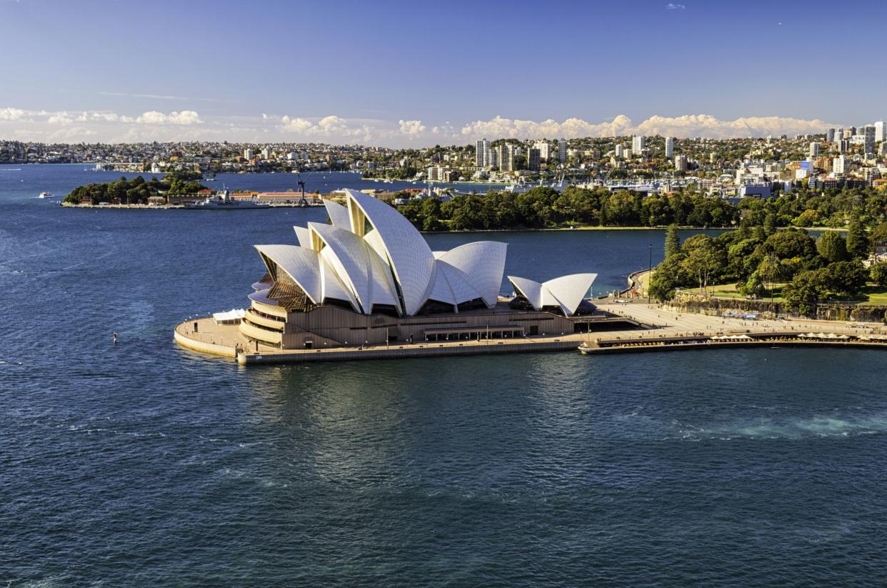 Sydney Australia - August 4, 2017: A clear morning in Sydney, New South Wales, and this is the view looking across Circular Quay towards the iconic shape of the city's Opera House. In the distance we see the Royal Botanic Gardens.