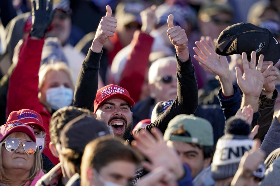 Supporters cheer as cameras point their way as they await President Donald Trump for a campaign stop, Saturday, Oct. 31, 2020, at the Butler County Regional Airport in Butler, Pa. (AP Photo/Keith Srakocic)