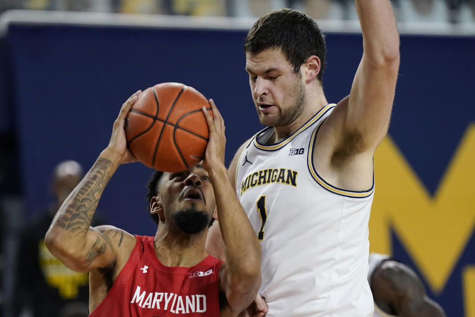 Maryland guard Eric Ayala, left, is defended by Michigan center Hunter Dickinson (1) during the first half of an NCAA college basketball game, Tuesday, Jan. 19, 2021, in Ann Arbor, Mich. (AP Photo/Carlos Osorio)