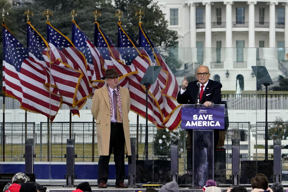 FILE - Chapman University law professor John Eastman stands at left as former New York Mayor Rudolph Giuliani speaks in Washington at a rally in support of President Donald Trump, called the "Save America Rally" on Jan. 6, 2021. An effort to disbar Eastman, who devised ways to keep former President Donald Trump in the White House after his defeat the 2020 election, will begin Tuesday, June 20, 2023, in Los Angeles. Eastman is expected to spend the day testifying before the State Bar of California in a proceeding that could result in him losing his license to practice law in the state. (AP Photo/Jacquelyn Martin, File)