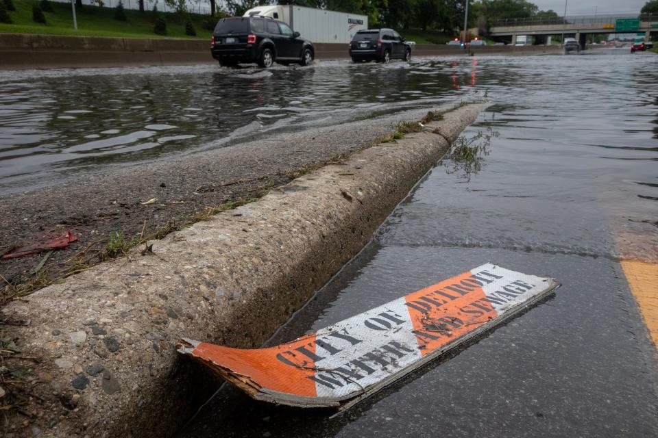 A broken city of Detroit water and sewage sign sits near a flooded Interstate 94 section in Detroit on Friday, Aug. 25, 2023.