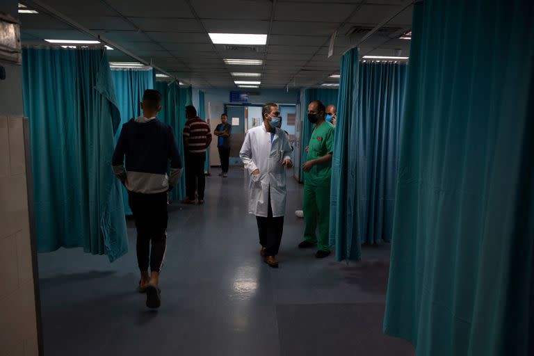 Médicos y médicos palestinos caminan dentro de la sala de emergencias del hospital Shifa en la ciudad de Gaza, el jueves 13 de mayo de 2021. Hace apenas unas semanas, el débil sistema de atención médica de la Franja de Gaza estaba luchando con un aumento desbocado de casos de coronavirus. Ahora, los médicos de todo el abarrotado enclave costero están tratando de mantenerse al día con una crisis muy diferente: heridas por explosiones y metralla, cortes y amputaciones.