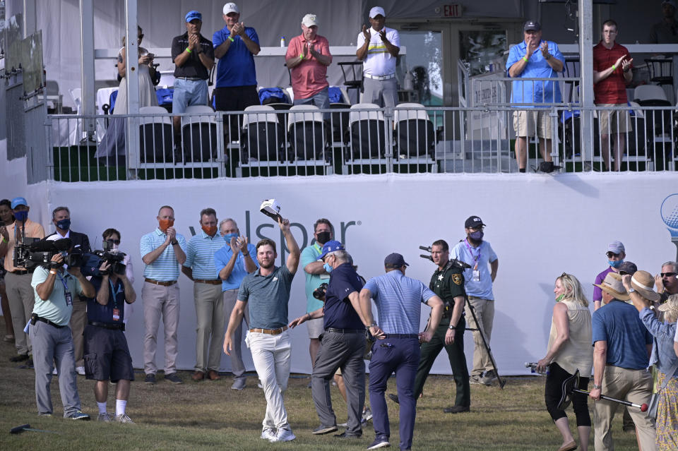 Sam Burns waves his hat to the crowd on the 18th green after winning the Valspar Championship golf tournament, Sunday, May 2, 2021, in Palm Harbor, Fla. (AP Photo/Phelan M. Ebenhack)