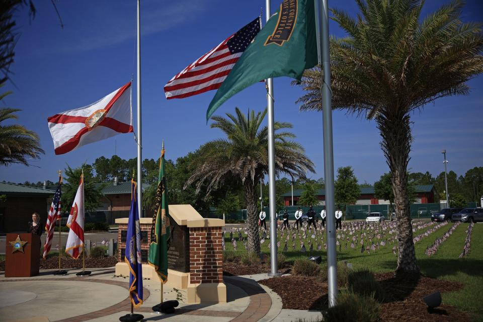 Walker Mullin sings "Amazing Grace" during a law enforcement memorial service Wednesday at the Nassau County Sheriff's Office as flags representing all law enforcement killed nationwide in 2021 are on the lawn nearby.