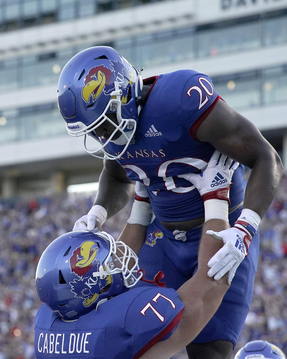 Kansas running back Daniel Hishaw Jr. (20) celebrates with offensive lineman Bryce Cabeldue (77) after scoring a touchdown during the first half of an NCAA college football game against Tennessee Tech Friday, Sept. 2, 2022, in Lawrence, Kan. (AP Photo/Charlie Riedel)