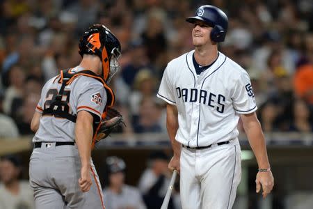 Jul 30, 2018; San Diego, CA, USA; San Diego Padres left fielder Wil Myers (right) reacts after striking out to end the seventh inning as San Francisco Giants catcher Buster Posey makes his way to the Giants dugout at Petco Park. Jake Roth-USA TODAY Sports