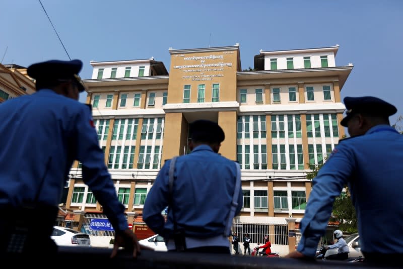 Police officers stand guard at the Municipal Court of Phnom Penh