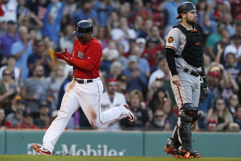 Boston Red Sox's Rafael Devers, left, scores behind Baltimore Orioles' Austin Wynns on an RBI-single by Xander Bogaerts during the seventh inning of a baseball game in Boston, Sunday, Sept. 29, 2019. (AP Photo/Michael Dwyer)