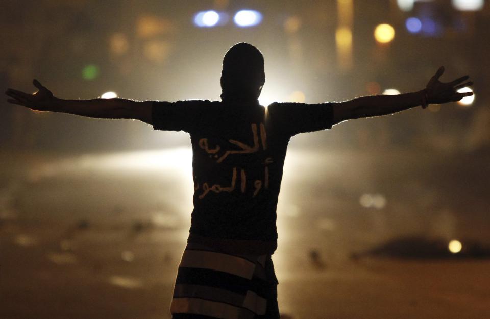 �A protester passionately shouts slogans at riot police during clashes in front of the presidential palace in Cairo. The words on the shirt reads, "Freedom or Death." (Reuters)