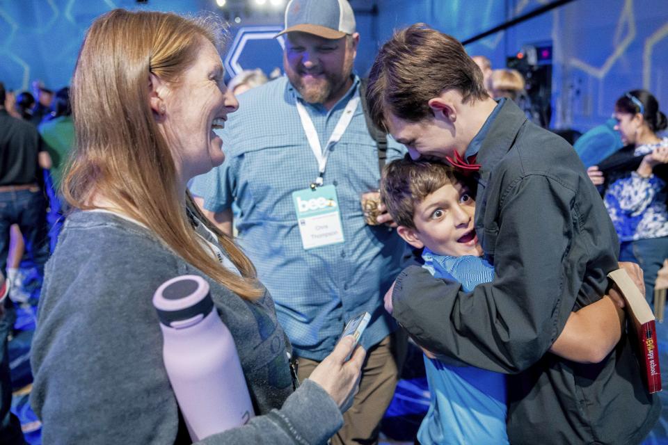 Nash Thompson, center right, reacts after his brother, Archer Thompson, 13, right, from Oklahoma City, Okla., passed the first round of the the Scripps National Spelling Bee, Tuesday, May 30, 2023, in Oxon Hill, Md. Looking on are their parents Leigh Thompson, left, and Chris Thompson, second left. (AP Photo/Nathan Howard)