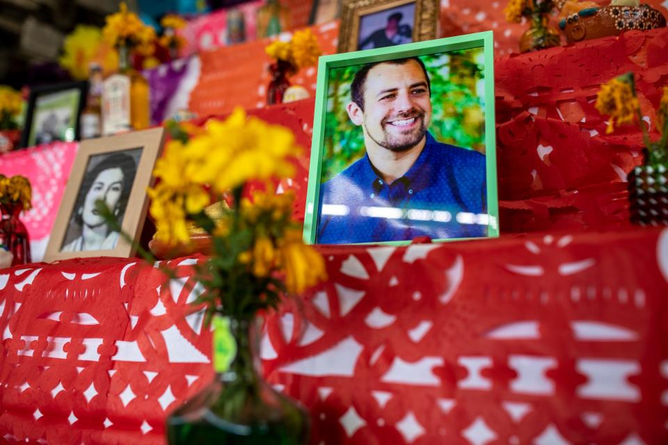 Food and pictures of loved ones that have passed are placed on the “ofrenda” outside in preparation for the inaugural Dia de los Muertos Tianguis/Festival at La Jalisciense Supermercado & Taqueria in southwest Detroit on Monday, Oct. 30, 2023. An ofrenda is an altar, built to honor lost loved ones. Offerings are placed upon the ofrenda, to help us remember, learn about, and celebrate their lives. Traditional ofrendas are full of symbols and meaning, which have a long history with the holiday and people.