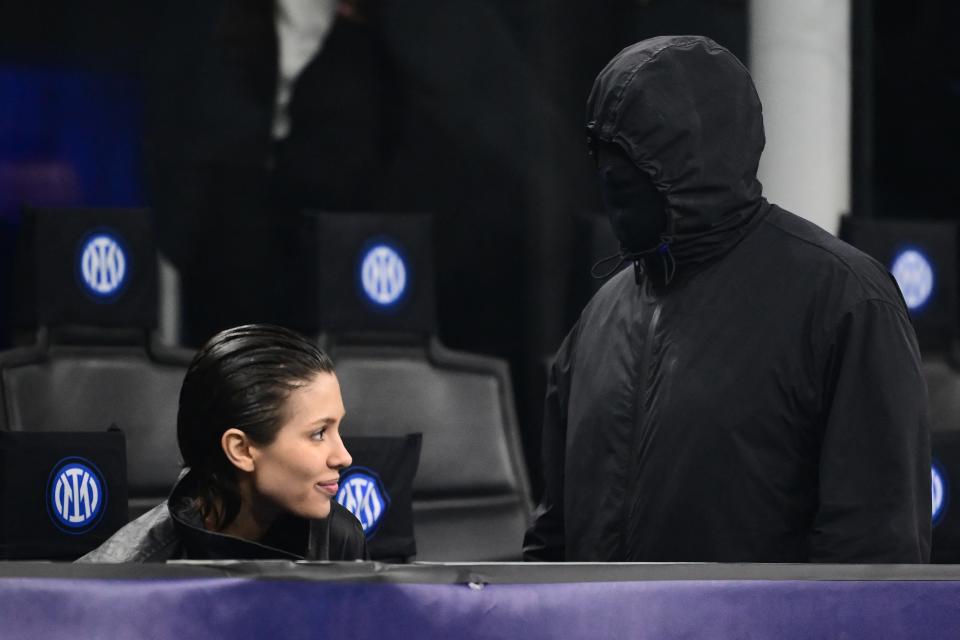 Ye, right, and partner Bianca Censori attend a UEFA Champions League match between Inter Milan and Atletico Madrid at the San Siro Stadium in Milan, Italy, on Feb. 20, 2024. The rapper opted for the mysterious with his game-day attire, wearing a black zip-up jacket with a matching mask that covered his entire face.