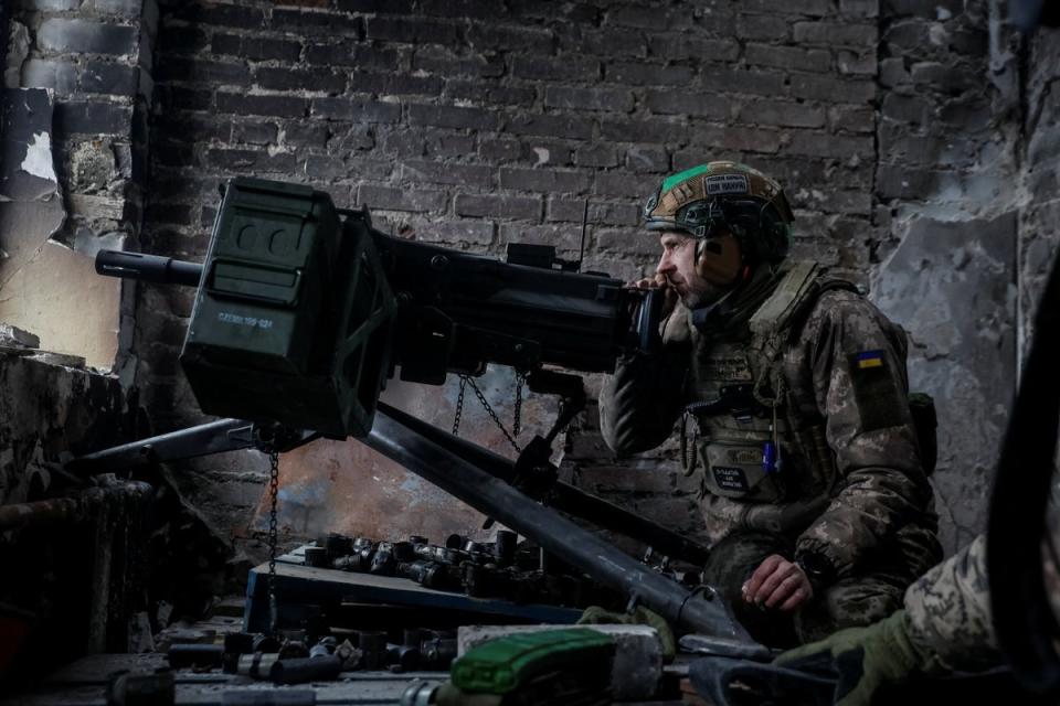 Ukrainian serviceman near an automatic grenade launcher in Bakhmut (via REUTERS)