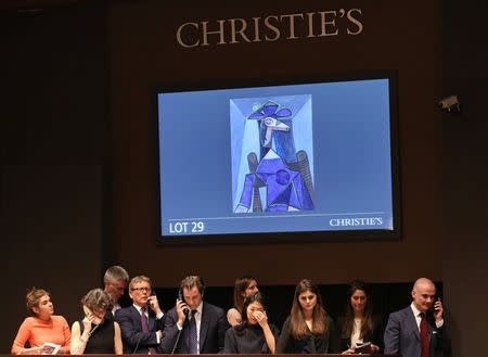 Christie's employees look on as a moderator facilitates the sale of an artwork titled "Portrait de femme (Dora Maar)" by artist Pablo Picasso during a Christie's auction in New York May 6, 2014. REUTERS/Adam Hunger