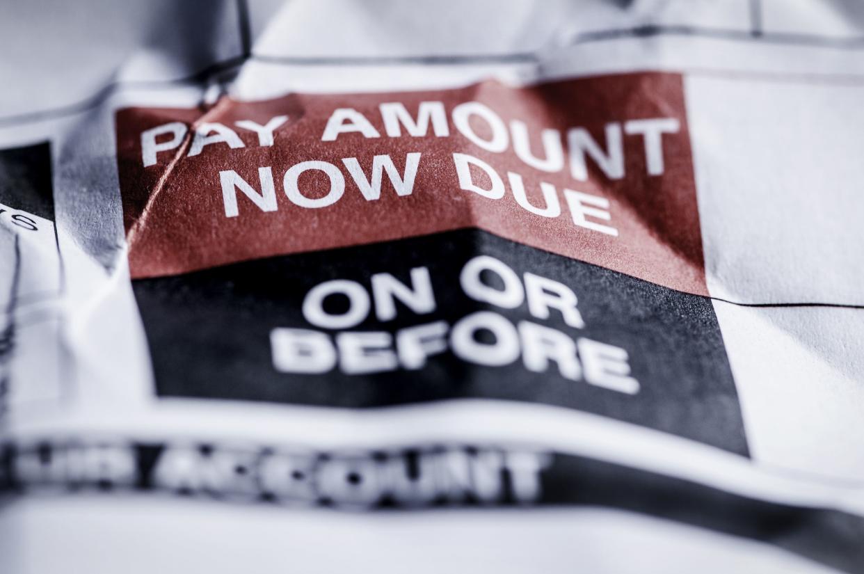 consumer credit debt payment now due on crumpled paper