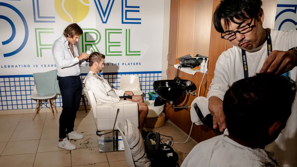 Julien Farel (left) cuts the hair of US Open player Austin Krajicek at Farel's salon in Arthur Ashe stadium in New York on August 30. - Will Lanzoni/CNN