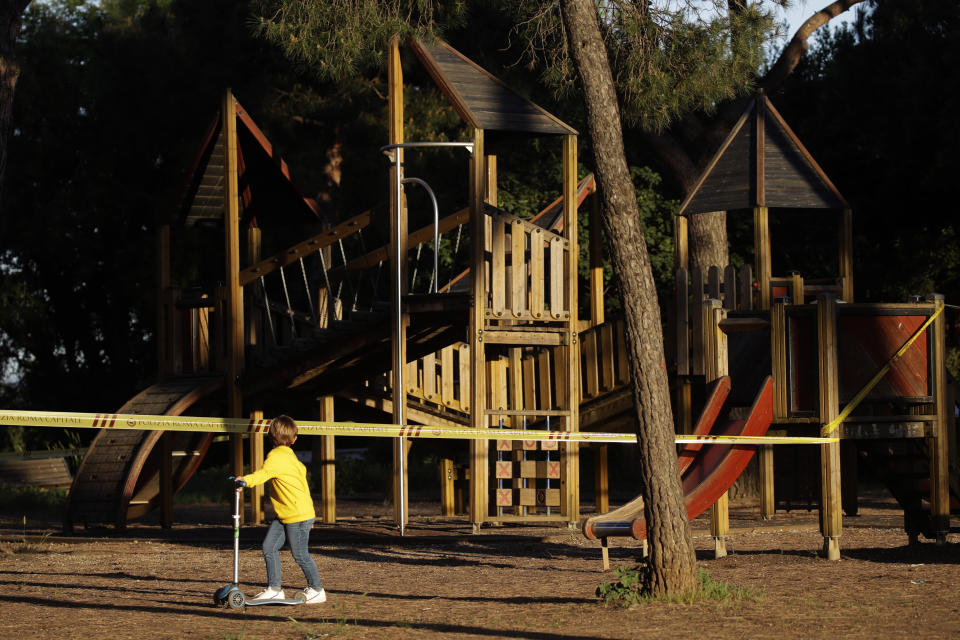 Un niño pasa por una zona de juegos acordonada en el Parque Villa Pamphili que recién abrió después de varias semanas cerrado debido a la cuarentena por el coronavirus, el 4 de mayo de 2020 en Roma, Italia. (AP Foto/Alessandra Tarantino)