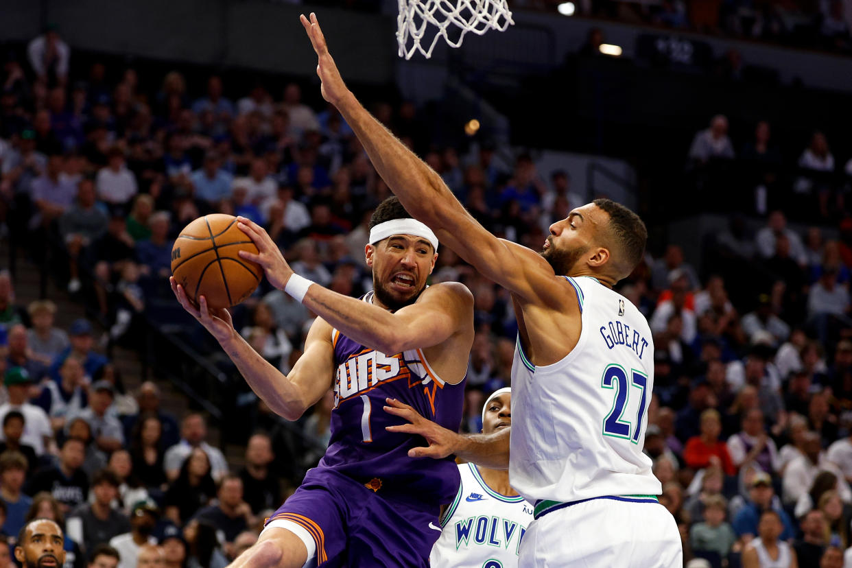 MINNEAPOLIS, MINNESOTA - APRIL 14: Devin Booker #1 of the Phoenix Suns passes the ball against Rudy Gobert #27 of the Minnesota Timberwolves in the first quarter at Target Center on April 14, 2024 in Minneapolis, Minnesota. The Suns defeated the Timberwolves 125-106. NOTE TO USER: User expressly acknowledges and agrees that, by downloading and or using this photograph, User is consenting to the terms and conditions of the Getty Images License Agreement. (Photo by David Berding/Getty Images)