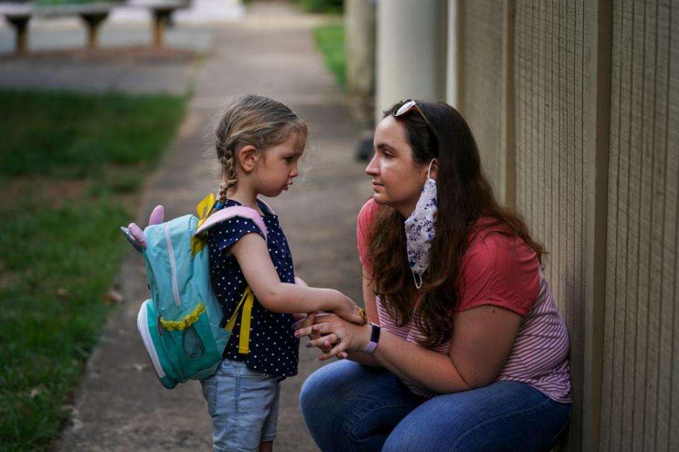 Aug. 27: After reluctantly deciding to send their 4-year-old daughter Beatrice back to daycare, Sarah McClusky consoles her at their home in Reston, Virginia. (Getty Images)