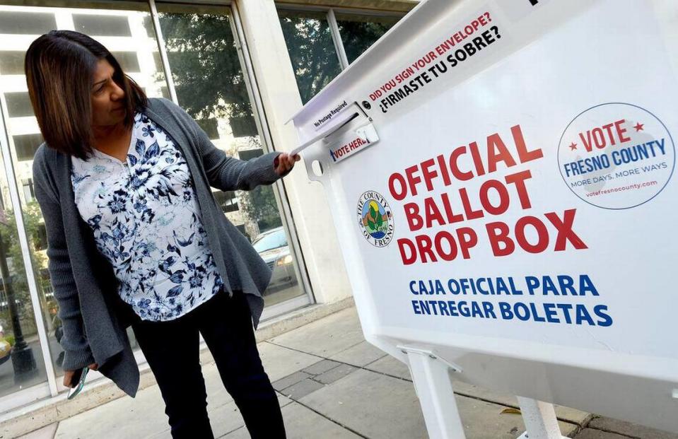 Voter Eva Frias casts her ballot at the drop box at the Fresno County Elections Office in downtown Fresno, March 3, 2020.