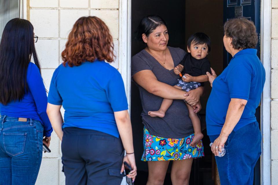 Gloria Gomez, right, founder and CEO of Galilee Center, checks on Peruvian asylum seeker.