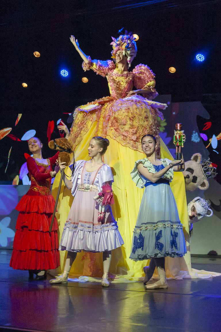 Imagen de la fertilidad, Mamá Gigogne trae en su miriñaque a sus "hijos", con ofrendas que son coloridas danzas de carácter para recibir a los viajeros en "El mundo de los personajes"