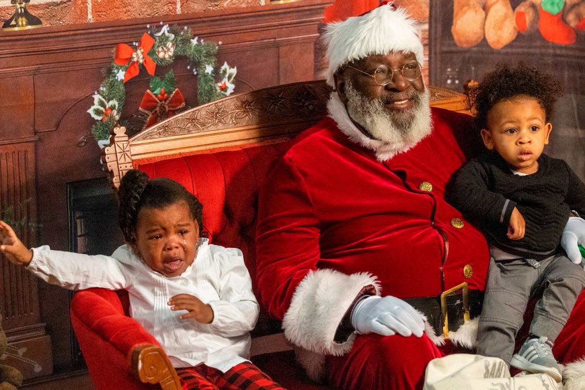 Kinsley Allen, 2, left and Kyel Jones, 1, have their photograph taken with Santa Claus, aka Joe Griffin, or Santa Joe, at the Hayti Heritage Center in Durham Wednesday, Dec. 21, 2022.