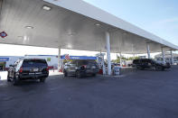 A Department of Public Safety vehicle, right, leaves a gas station while two others are parked at pumps, Wednesday, Sept. 22, 2021, in Del Rio, Texas. The “amistad,” or friendship, that Del Rio, Texas, and Ciudad Acuña, Mexico, celebrate with a festival each year has been important in helping them deal with the challenges from a migrant camp that shut down the border bridge between the two communities for more than a week. Federal officials announced the border crossing would reopen to passenger traffic late Saturday afternoon and to cargo traffic on Monday. (AP Photo/Julio Cortez)