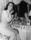 <p>Elizabeth gives fans a glimpse at how she achieves her movie star look as she poses at her vanity in 1948. </p>