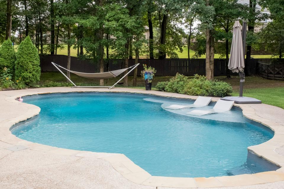 The great in-ground pool and an extended, covered patio helps the backyard feel like an oasis.
