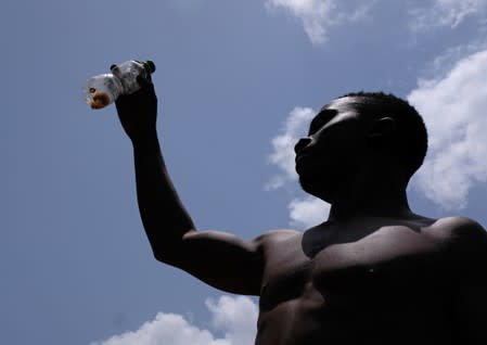 An informal gold miner holds up mercury in a bottle at a site in Bawdie