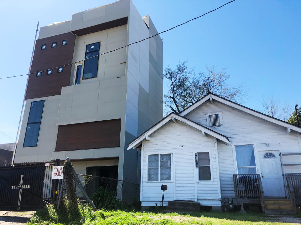 A newer apartment building built after Harvey (left) squeezes next to a pre-Harvey home in northeast Houston. (Photo: Sophie Kasakove)