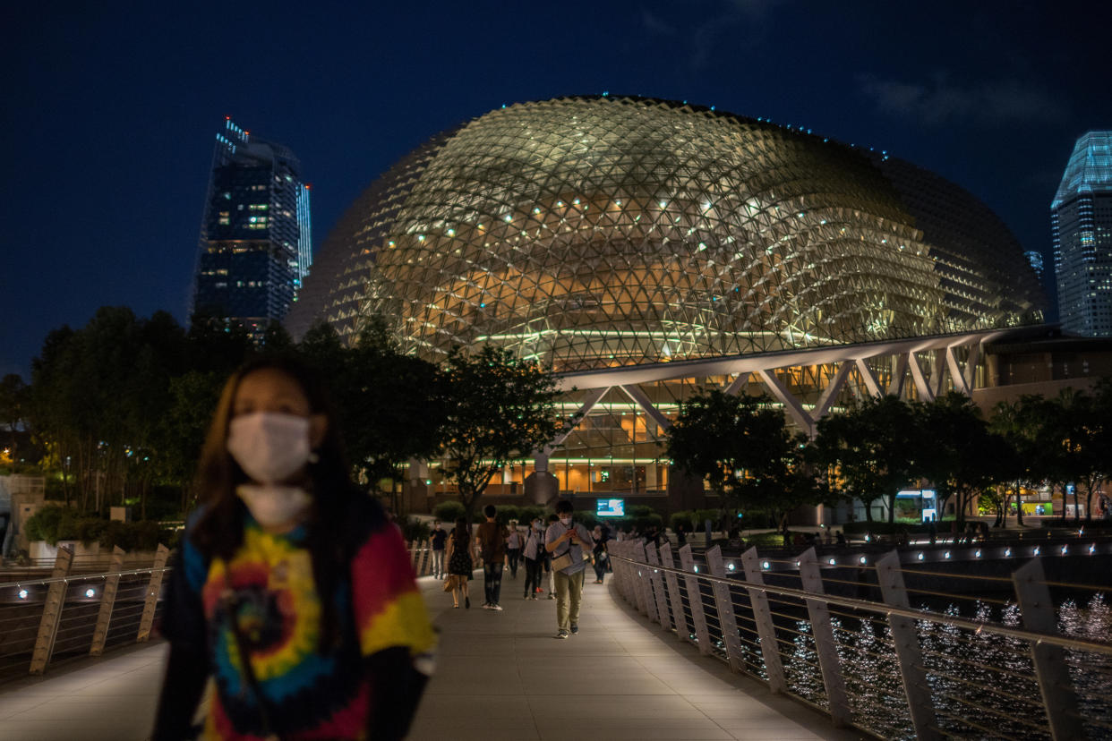 People wearing protective surgical masks walk towards the Merlion Park, a major tourist attraction in Singapore, on 12 February, 2020. (PHOTO: LightRocket via Getty Images)