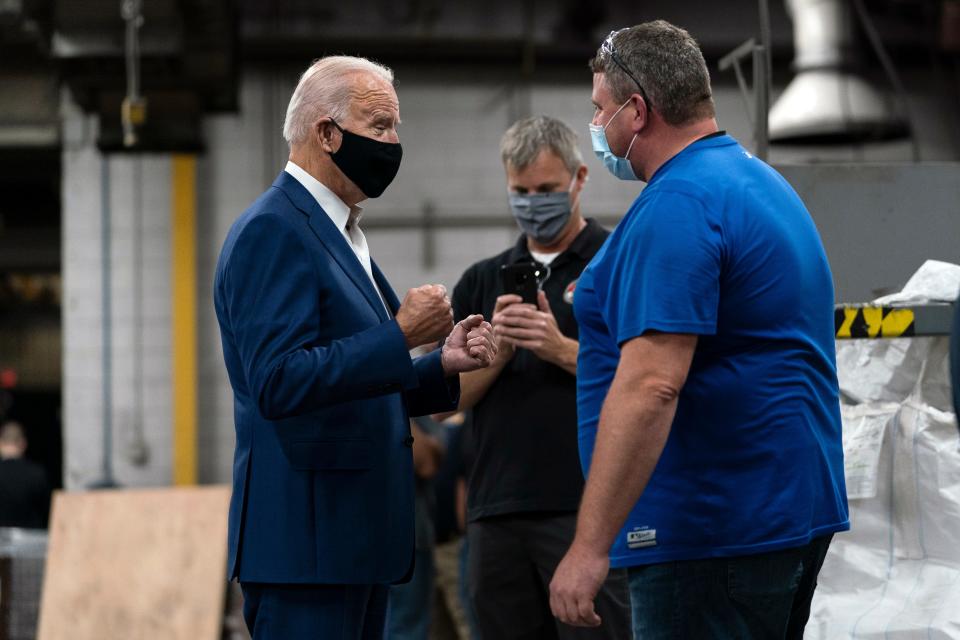 Democratic presidential candidate Joe Biden talks with workers as he tours the Wisconsin Aluminum Foundry in Manitowoc on Sept. 21, 2020.