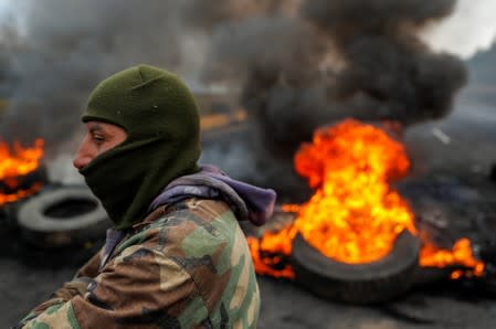 Un manifestante aparece junto a una barricada en llamas durante las protestas después de que el gobierno del presidente de Ecuador, Lenín Moreno, puso fin a subsidios al combustible, cerca de Machachi, Ecuador