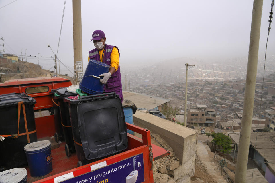 Un trabajador recoge los desechos mezclados con aserrín, como parte del programa de saneamiento alternativo, en el barrio de Pamplona Alta de Lima, Perú, el miércoles 20 de marzo de 2024. El servicio incluye el reparto de aserrín, la instalación del baño seco y el traslado de los desechos hacia un contenedor que semanalmente lleva 40 toneladas a un relleno sanitario. (AP Foto/Martín Mejía)