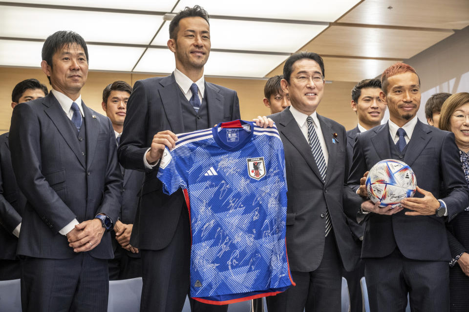 Japan's national soccer team head coach Hajime Moriyasu, left, defender Maya Yoshida, second left, and defender Yuto Nagatomo, right, pose with Japan's Prime Minister Fumio Kishida during a photo call with souvenirs before their meeting at the prime minister's office in Tokyo Thursday, Dec. 8, 2022, following the team's return from the Qatar 2022 World Cup. (Philip Fong/Pool Photo via AP)