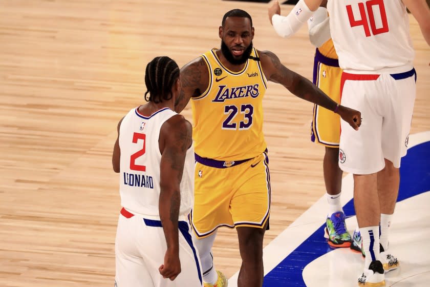 Los Angeles Lakers' LeBron James (23) talks with Los Angeles Clippers' Kawhi Leonard.