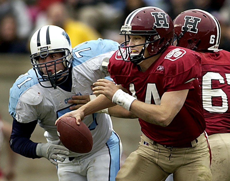 Harvard University quarterback Ryan Fitzpatrick scrambles away from Columbia University's Clint Eberlin during the first half of their game, Saturday Nov. 6, 2004, in Boston at Harvard Stadium. (AP Photo/Adam Hunger)