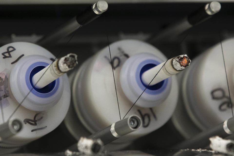 FILE - In this Thursday, Nov. 10, 2016 file photo, test cigarettes burn in a smoking machine at the Centers for Disease Control and Prevention in Atlanta. A decade after President Barack Obama signed the Family Smoking Prevention and Tobacco Control Act into law in 2009, health advocates say the Food and Drug Administration has yet to put in place the most sweeping changes envisioned by Congress. (AP Photo/Branden Camp)