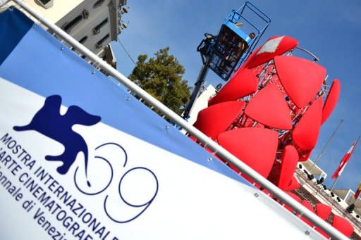 Workers stick the logo of the 69th Venice film festival on a display near the red carpet, August 2012. With much of the traditional cinema sector in a state of flux, Venice film festival participants said the industry is looking to a future in which the Internet will play an ever bigger role